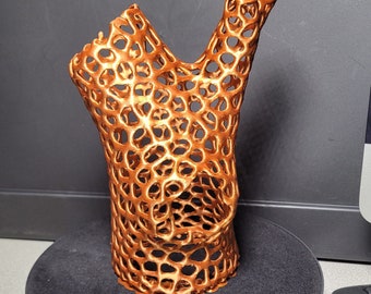 May include: A copper-colored, 3D printed sculpture with a lattice design. The sculpture is abstract and resembles a branch or a tree.