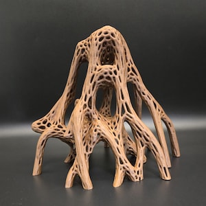 Puede incluir: Una escultura abstracta marrón con un diseño calado complejo. La pieza tiene una estructura similar a un árbol con múltiples ramas arqueadas y una superficie texturizada. La escultura se exhibe sobre un fondo oscuro.