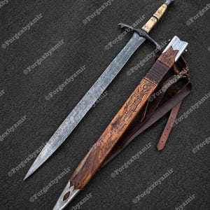 May include: A detailed image of a sword with a patterned blade and a wooden handle. The sword is accompanied by a wooden sheath with intricate carvings and a leather strap. The blade has a textured pattern.