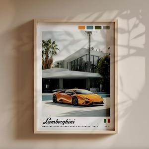 May include: Framed print featuring an orange Lamborghini sports car parked in front of a modern white house with palm trees. The print includes the Lamborghini logo and text: MANUFACTURED IN SANT'AGATA BOLOGNESE, ITALY.