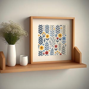 May include: A framed print with a white background and a colorful pattern of blue, yellow, and red flowers and leaves.