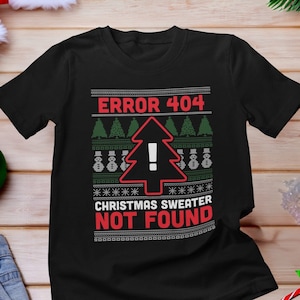 May include: Black Christmas jumper with a red and green design. The jumper features a Christmas tree with an exclamation mark and the text "ERROR 404 CHRISTMAS JUMPER NOT FOUND".