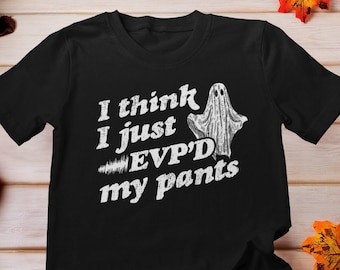 May include: Black t-shirt with a white ghost graphic and the text "I think I just EVP'D my pants".