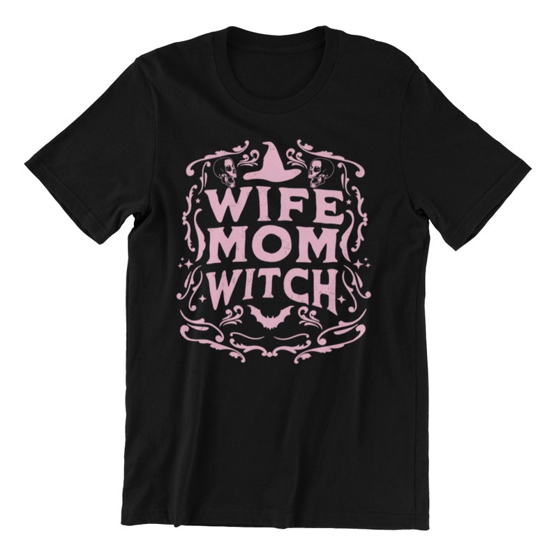 Pu&ograve; includere: Maglietta nera con un design grafico rosa che dice "Wife Mom Witch" con un cappello da strega e pipistrelli.