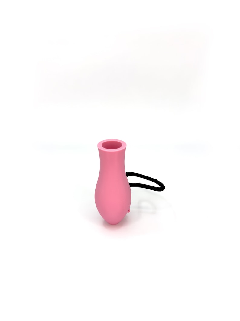 May include: A pink silicone bottle stopper with a black elastic band.
