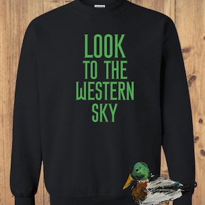 May include: Black sweatshirt with green text that reads "LOOK TO THE WESTERN SKY". A green-headed duck with brown and white feathers is in the bottom right corner of the image.