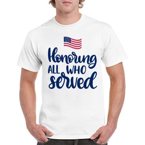 Peut inclure: T-shirt blanc avec l'inscription "Honoring ALL WHO SERVED" en bleu marine et un petit drapeau am&eacute;ricain. Le t-shirt est de style col rond.