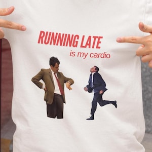 May include: White t-shirt with a red graphic that says "RUNNING LATE is my cardio". The graphic features two men, one in a suit and tie, the other in a suit and tie with a watch on his wrist. The man in the suit and tie is looking at his watch.