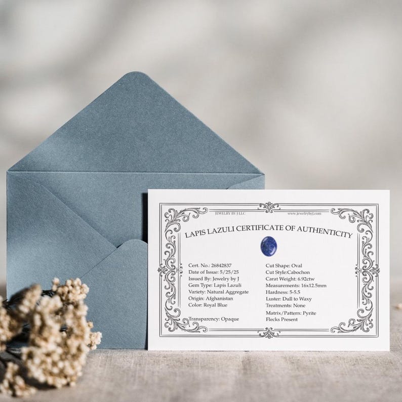 Pu&ograve; includere: Un certificato di autenticit&agrave; per Lapis Lazuli, con un'illustrazione di gemma ovale blu. Il certificato &egrave; su carta bianca con un bordo decorativo e le misure sono 16x12,5mm. Una busta blu e fiori secchi sullo sfondo.