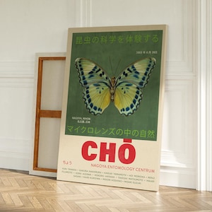以下が含まれることがあります： 緑色の背景に、黒と青の模様のある大きな黄色の蝶が描かれたヴィンテージポスター。ポスターには、「昆虫の科学を体験する」「マイクロレンズの中の自然」「ちょう CHO」「NAGOYA ENTOMOLOGY CENTRUM」という日本語の文字が書かれている。