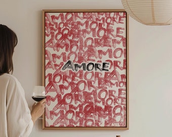 May include: A framed print with the word "Amore" written in black lettering on a red background. The print is hanging on a white wall. A glass of red wine and a bottle of wine are on a table in front of the print.