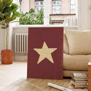 Pu&ograve; includere: Una stampa su tela rossa con una grande stella gialla al centro. La stella &egrave; un design semplice e disegnato a mano.