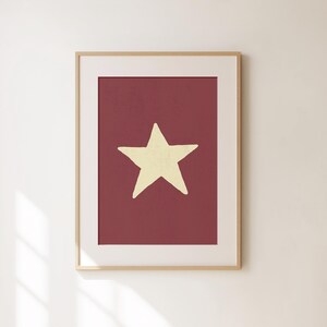 Pu&ograve; includere: Una stampa incorniciata con una singola stella gialla su uno sfondo bordeaux.