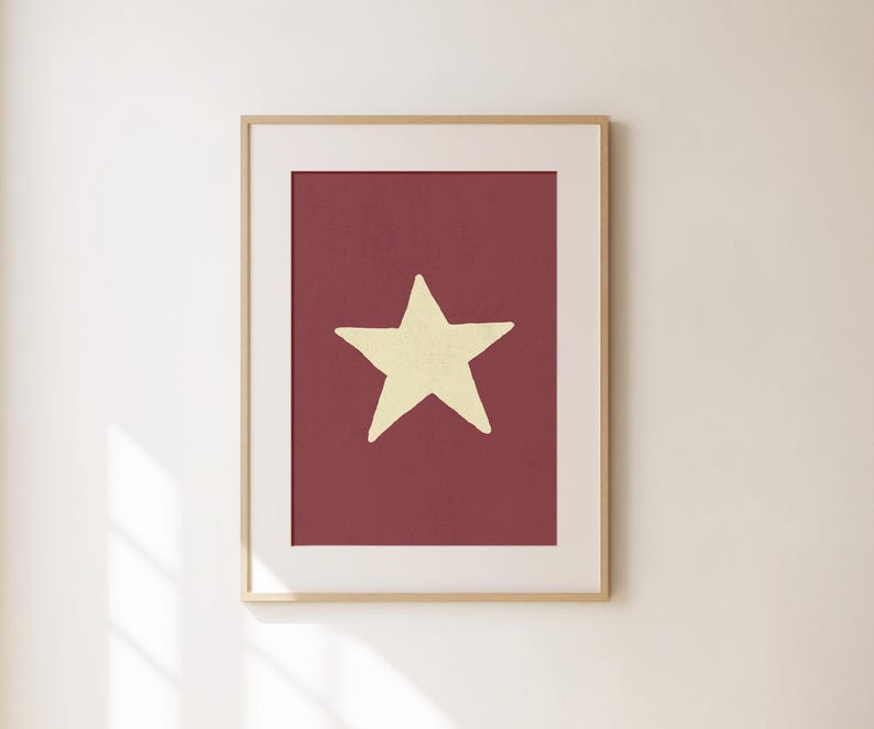 Pu&ograve; includere: Una stampa incorniciata con una singola stella gialla su uno sfondo bordeaux.