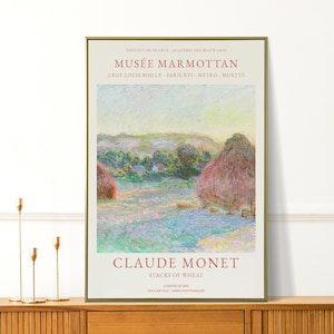 May include: A framed print of Claude Monet's "Stacks of Wheat" painting. The artwork depicts a field with haystacks, using pastel colours. The print includes the text "MUSÉE MARMOTTAN" and "CLAUDE MONET". The frame is gold.