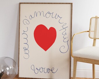 Può includere: Una stampa incorniciata con un cuore rosso al centro e il testo "l'amour s'eprit" e "toujours" scritto in un font corsivo attorno al cuore.