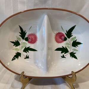 May include: A white oval serving dish with a brown rim, divided into three sections. The dish is decorated with a floral design featuring pink flowers and green leaves.