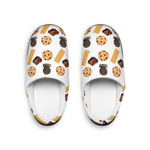 May include: A pair of white slippers with a pattern of cookies, brownies, and wafers.