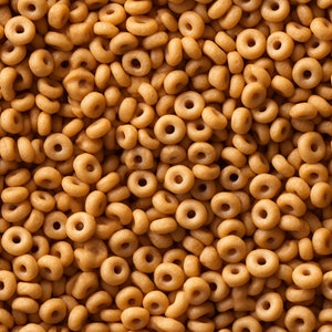May include: A close-up image of a large pile of brown, ring-shaped cereal. The cereal is arranged in a random pattern, creating a textured background.