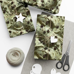 May include: Three gift boxes wrapped in green and brown paper with a chocolate chip ice cream pattern. The boxes are tied with twine and decorated with white paper stars and hearts.