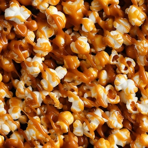 May include: Close-up of popcorn covered in a generous amount of caramel sauce. The popcorn is white and the caramel sauce is a rich brown color.