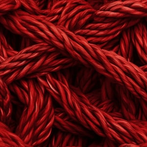 May include: A close-up of a tangled mass of thick, red cords. The cords are woven together in a complex pattern, creating a textured and abstract background.