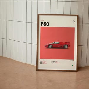 May include: A framed print featuring a red Ferrari F50 sports car against a red background. The print includes the car's specifications and the text "Ferrari F50". The frame is made of wood.