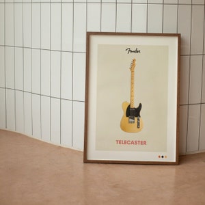 Może przedstawiać: Oprawiony wydruk z gitarą Fender Telecaster. Gitara ma kremowy korpus i czarny pickguard. Słowo "Fender" znajduje się nad gitarą, a "TELECASTER" pod nią na czerwono. Rama jest drewniana.