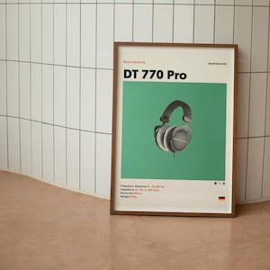 May include: A poster with a green background featuring a black and silver Beyerdynamic DT 770 Pro headphone. The poster has the text "Beyerdynamic DT 770 Pro" in white and the text "Frequency Response: 5 - 35,000 Hz, Impedance: 32 ohms, Driver size: 45mm, Weight: 270g" in black.