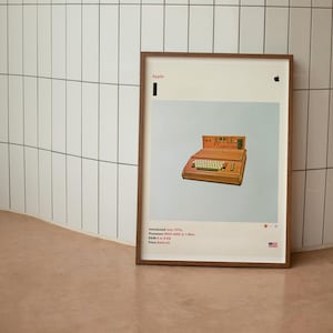 May include: A framed poster with a light blue background featuring a vintage Apple computer with the text "Apple Computer" on the front. The poster includes the text "Introduced July 1974", "Processor MOS 6502 @ 1 MHz", "RAM 4 or 8 KB", and "Price $666.66".