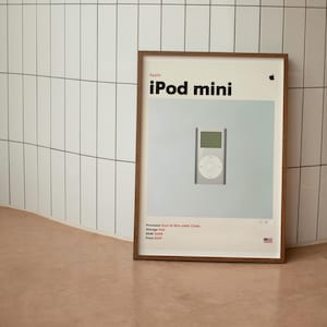 May include: A framed poster featuring an Apple iPod mini. The poster has a light blue background with the iPod in the center. The text "Apple iPod mini" is at the top. The poster includes specifications and a small American flag.