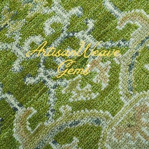 May include: Close-up of a green and white patterned rug with a woven texture. The rug has a subtle floral design and is made of soft, plush fibres. The text "Artisan Weave Gems" is visible in the image.