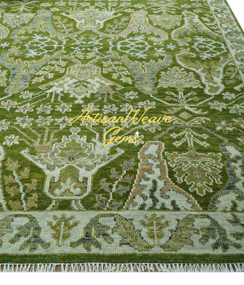 May include: A green and cream patterned rug with a floral design. The rug has a fringe border and features the text "Artisan Weave Gems".