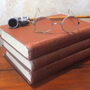 Lunettes anciennes à monture métallique ovale et ronde, branches en fil de fer, style Dark Academia, accessoires victoriens et édouardiens.