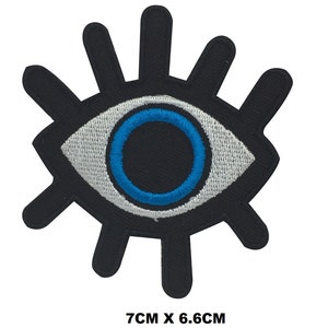 May include: A black and white eye with a blue iris and eyelashes. The eye is 7 inches by 6.6 inches.