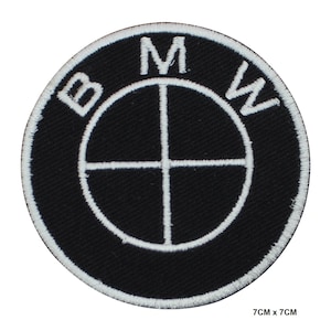 Peut inclure: Un écusson rond brodé noir avec le logo BMW en blanc. Le logo comprend les lettres "BMW" et un emblème circulaire avec un design en croix. Dimensions : 7 cm x 7 cm.