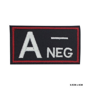 Puede incluir: Un parche bordado negro con un borde blanco y costuras rojas. El parche dice "A-NEG" en letras blancas.