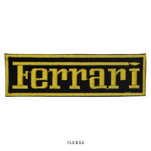 Può includere: Toppa ricamata con la scritta "Ferrari" in filo giallo su sfondo rettangolare nero. La toppa misura 29,2 x 8,9 cm.
