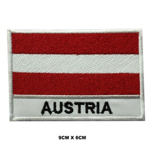 Op de afbeelding: Gestikt patch met de Oostenrijkse vlag met rode en witte strepen en het woord "AUSTRIA" in zwarte letters. Het patch is 9 cm bij 6 cm.