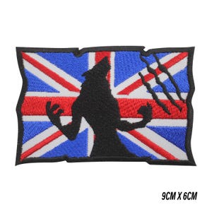 May include: Embroidered patch with a black wolf silhouette against a Union Jack flag background. The patch has a distressed border and claw marks. The dimensions are 9cm x 6cm.