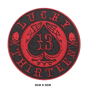 May include: A black and red embroidered patch with a spade design and the text "WFCX WHITER THAN", and "TERRY" on the bottom. The patch is 9 cm by 9 cm.