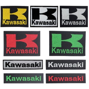 Könnte beinhalten: Eine Sammlung von neun rechteckigen gestickten Aufnähern mit dem Kawasaki-Logo und Schriftzug. Fünf Aufnäher zeigen ein großes stilisiertes K mit dem Wort Kawasaki darunter in Gelb, Schwarz, Weiß, Rot und Grün. Vier Aufnäher zeigen den Text Kawasaki.