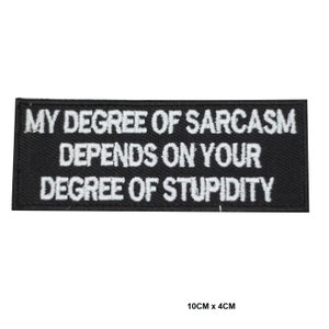 May include: Black rectangular patch with white embroidered text: "MY DEGREE OF SARCASM DEPENDS ON YOUR DEGREE OF STUPIDITY." The patch measures 10cm x 4cm. The patch is designed to be sewn or ironed onto clothing or accessories.