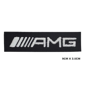 Peut inclure: Écusson rectangulaire noir avec texte "AMG" brodé en blanc et un motif de barres parallèles. Le patch mesure 9 cm x 2,5 cm.