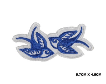 May include: Blue embroidered patch of two swallows facing each other. The patch is 5.7 cm by 4.5 cm.