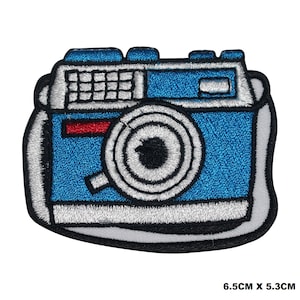 Peut inclure: Patch brodée bleu et blanc à repasser représentant un appareil photo vintage avec une bande rouge. Le patch mesure 6,5 cm sur 5,3 cm.