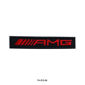 Könnte beinhalten: Schwarzer rechteckiger Aufnäher mit den roten Buchstaben "AMG". Der Aufnäher ist 9 cm lang und 2,5 cm breit. Die Buchstaben sind auf schwarzem Hintergrund gestickt. Für Autoenthusiasten.