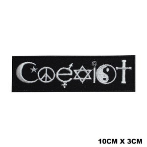 May include: Black embroidered patch with the word "Coexist" in white lettering. The word is surrounded by various religious symbols including a crescent moon, a peace sign, a cross, a Star of David, and a yin-yang symbol. The patch measures 10 cm by 3 cm.