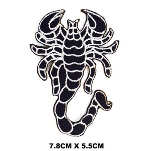 May include: Black and white embroidered scorpion patch with a white outline. The patch is 7.8 cm by 5.5 cm.