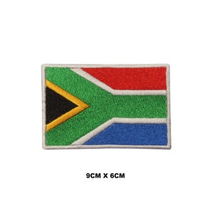 May include: An embroidered South African flag patch with the colors green, yellow, black, red, white, and blue. The patch is 9 cm by 6 cm.